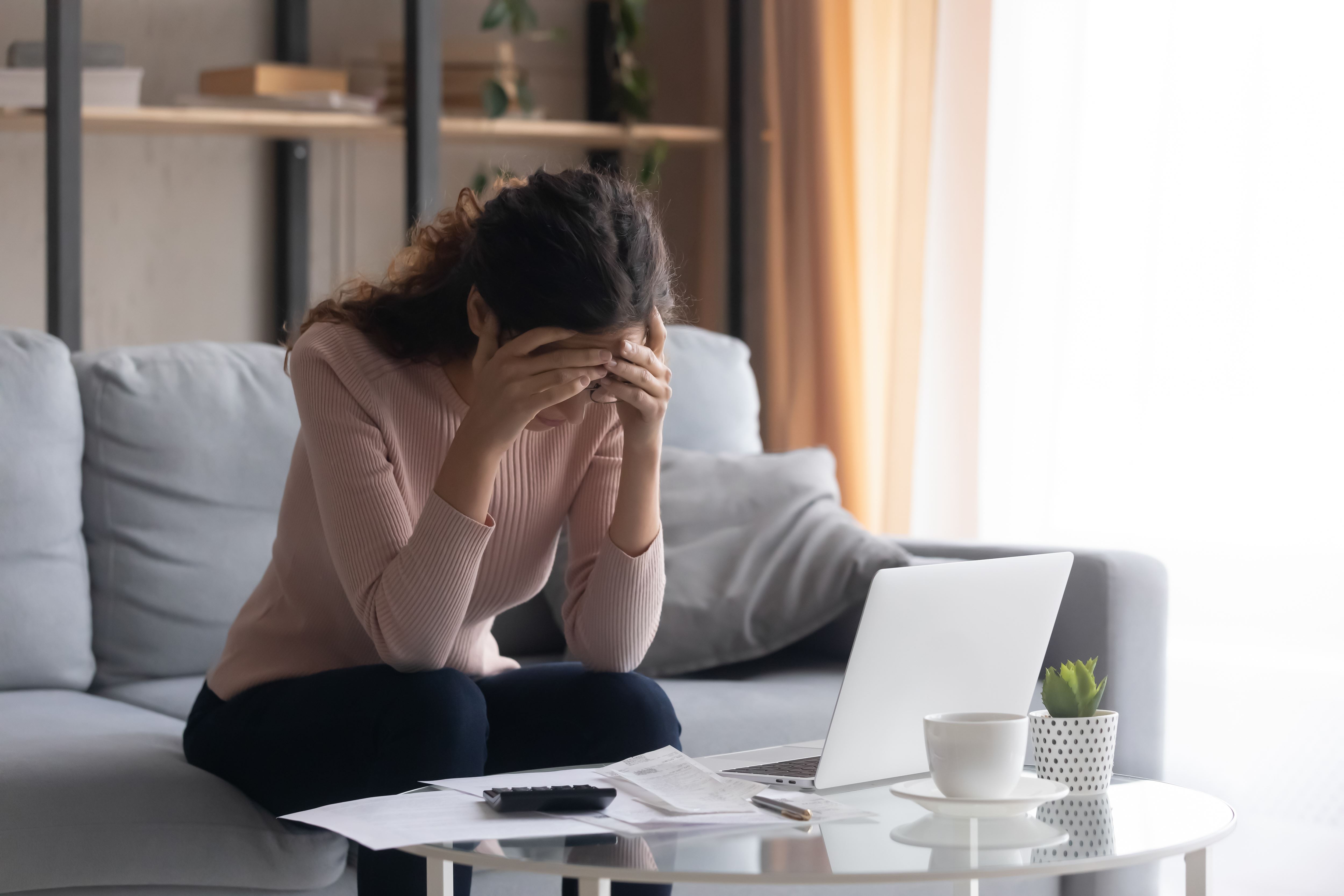 Woman stressing over finances in her living room